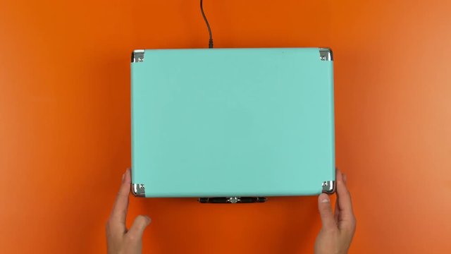  Top view hands putting record onto play on colorful vintage record player