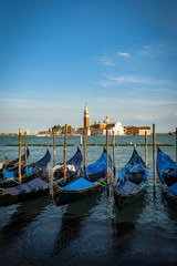 Moored or docked gondolas in Venice, Italy across the lagoon from San Giorgio Maggiore church in the district (sestiere) of San Marco