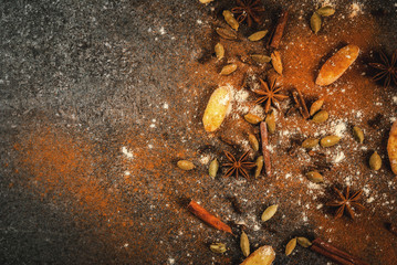 Mixture of dried ground spies for hot spicy tea or indian masala chai - cinnamon, anise, cardamom, ginger, on a white marble table - chili, paprika, curry, turmeric, ginger. Copy space top view