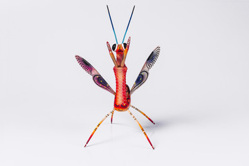 Mexican red mantis alebrije isolated in white background in front view