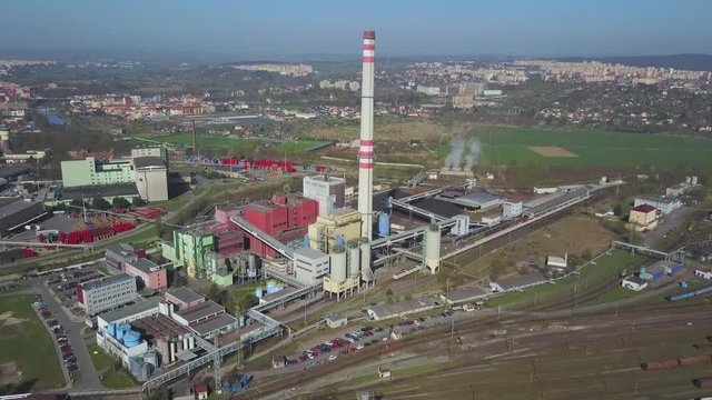 Flight over heating plant and thermal power station. Aerial view of combined modern power station for city district heating and generating electrical power. Industrial zone with railway in the city.