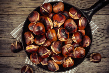 chestnuts in a pan on a wooden background
