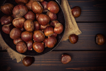 chestnuts in a pan on a wooden background