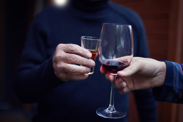 Hands holding glasses and toasting, happy festive moment, luxury celebration concept. People, men, leisure, friendship and celebration concept - happy male friends drinking and clinking glasses.