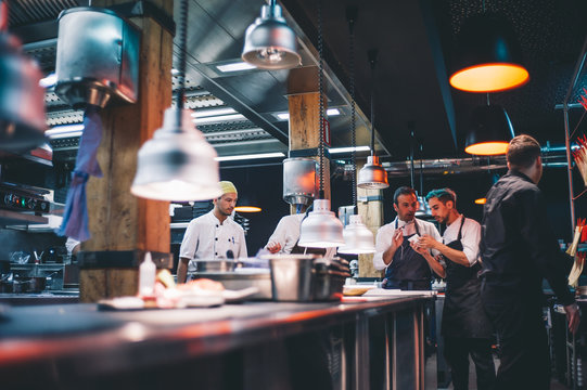 Chef cooking instructing cooks.