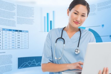 Composite image of smiling female surgeon using a laptop