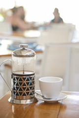 Obraz premium Coffee pot and a coffee cup on wood table