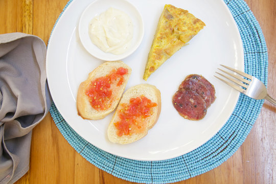 Spanish potato tortilla, bread and sauce served on the plate
