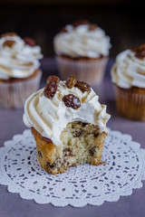 Bitten cupcake with raisins on doilies
