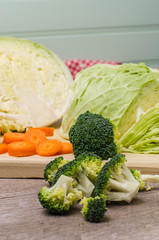 Fresh vegetables from the garden, carrots, cabbage, broccoli, onion and garlic on a wooden table