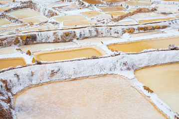 Terraced salt pans also known as "Salineras de Maras", among the most scenic travel destination in Cusco Region, Peru. View from above of the colorful ponds' reflecting surfaces.