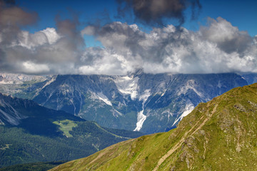 Clouds with flat bases cover the Dreischusterspitze / Punta dei Tre Scarperi peak in Sexten Dolomites, view from grassy slopes of Carnic Alps main ridge, South Tyrol, Italy, Europe