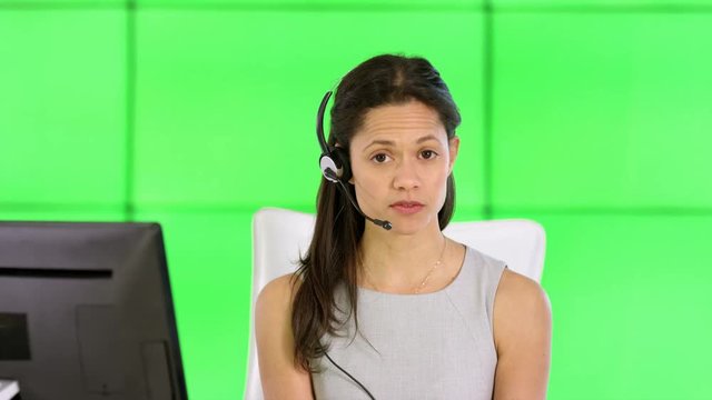  Smiling customer service operator talking to customer on green background