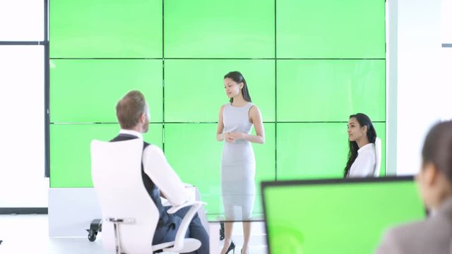  Businesswoman giving presentation & interacting with green screen video wall
