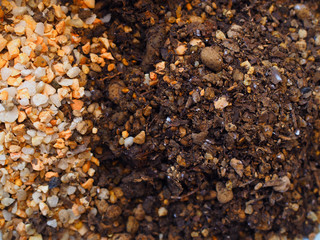 Separated pile of small white and yellow stone for covering the other half black dry grainy texture sand and soil, used for mixing and preparing the cultivating cactus por