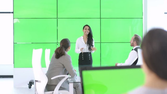  Corporate business team in a meeting with green screen video wall behind