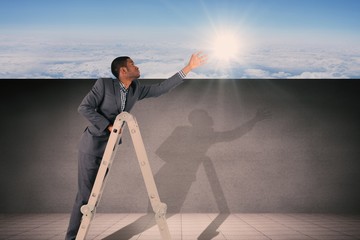 Composite image of businessman climbing up ladder