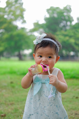 Asian Adorable baby girl playing in park. Beautiful smiling cute baby