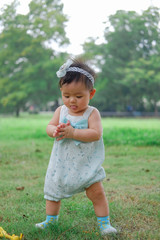 Asian Adorable baby girl playing in park. Beautiful smiling cute baby