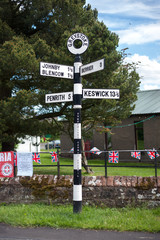 Traditional black and white signpost in the village of Greystoke, Cumbria
