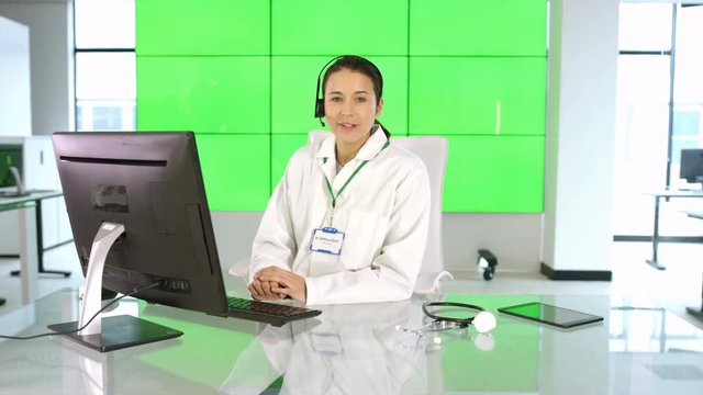  Happy medical service adviser talking to customer/patient on green background