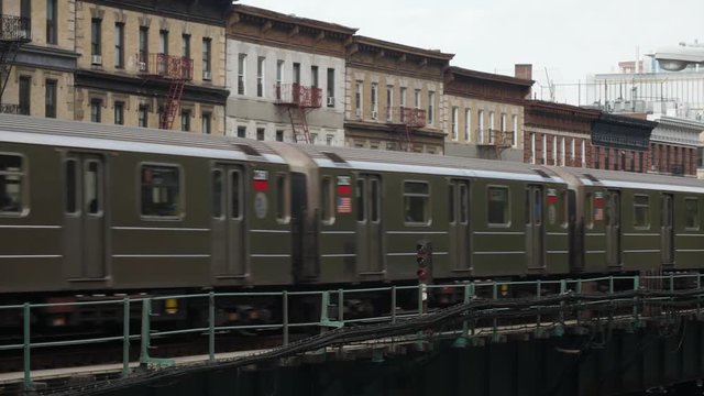 A New York City subway train passes by Harlem apartment buildings on an elevated track.  	