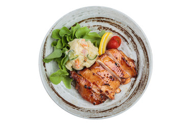 Isolated Top view of Teriyaki chicken served with potato salad, sliced lemon, totmato and green oak in round stone plate.