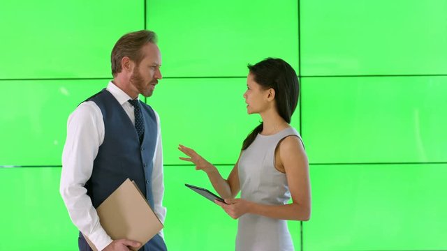  Business man & woman looking at tablet with green screen, on green background
