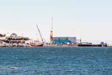 Seaport industrial commercial dock on Gaspesie coast of Quebec Canada with port, ships and construction cranes