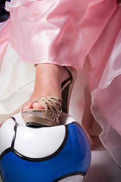 Mujer con zapatillas rompe un balón de futbol