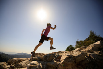 woman trail runner running at mountain top