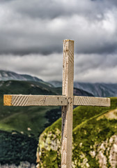 A wooden cross is set on top of the mountain.