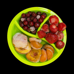 Frozen peaches apricot cherries strawberries isolated on black background