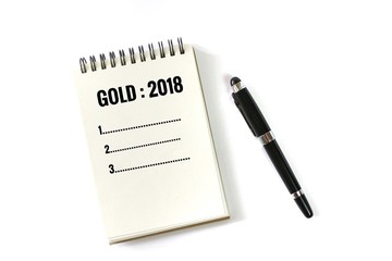 Flat lay photo with notebook and pan in gold 2018 plan list isolated on white background