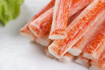 Closeup of crab stick with green lettuce and coriander, pepper and other spices.