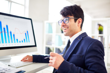 Successful financier having talk to colleague during working day in office