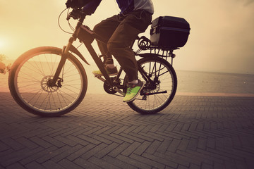 Fototapeta na wymiar one male cyclist cycling at sunrise seaside