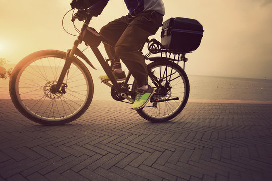 one male cyclist cycling at sunrise seaside