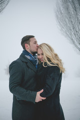 Glückliches Paar in Winterlandschaft gehen mit Wintermantel spazieren