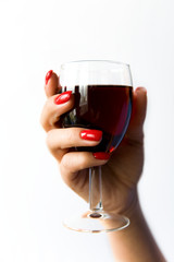 A glass of red wine in a beautiful woman's hand.