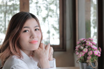 Close up prettyface of young Asian woman smiling and looking  camera at room with copy space background.