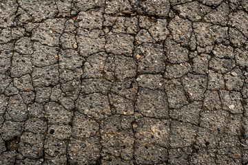Old worn and cracked asphalt with cracks. Old asphalt background