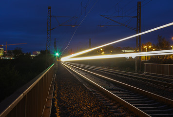 Fototapeta na wymiar Train trails in night on long exposure with green light
