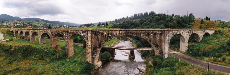 Fototapeta na wymiar Panorama of the old austrian bridge through the river at the Karpatian mountains view from left middle side near river