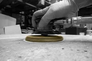Man using compressed air orbital sander with selective color