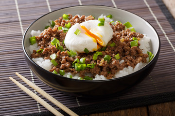 Delicious breakfast: spicy stewed minced meat with poached egg and rice close-up. horizontal
