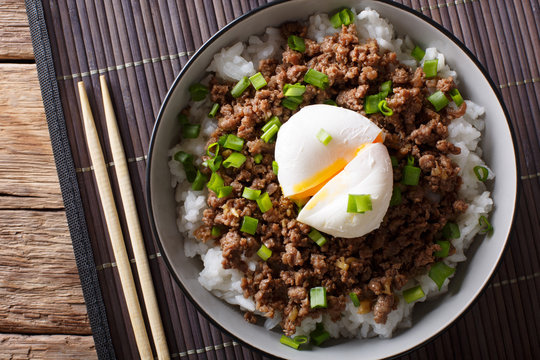Beef Soboro with egg poached, rice and green onion close-up. Horizontal top view
