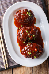 Homemade Japanese hambagu steak with sauce close-up. Vertical top view