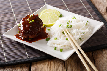 Japanese food: hamburg steak or hambagu with a spicy sauce and rice noodles close-up. horizontal