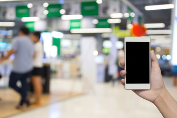 blurred photo and smartphone on people in shopping mall with bokeh.